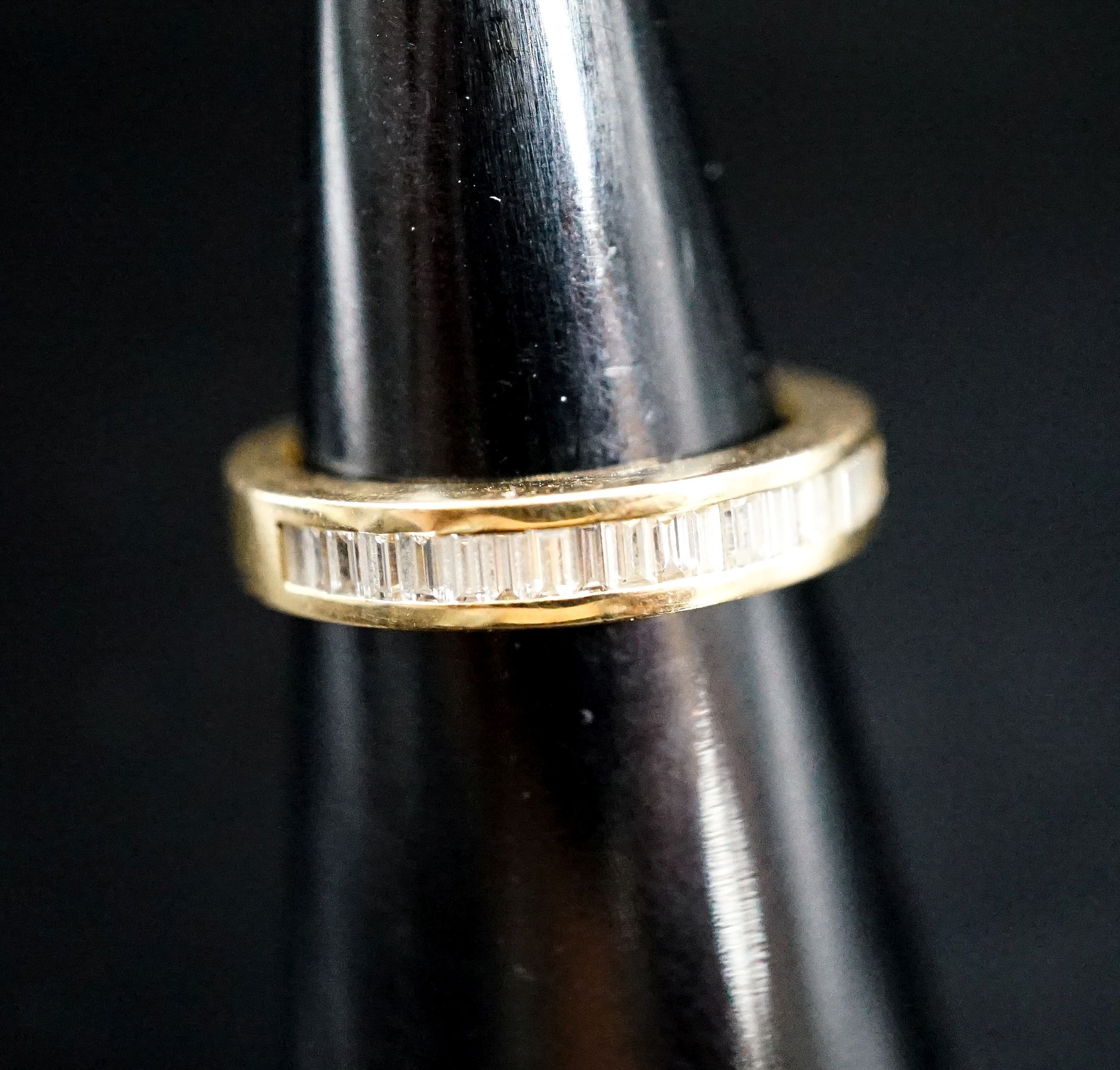 A continental 750 yellow metal and baguette cut diamond set half eternity ring, size L, gross 5.1 grams.